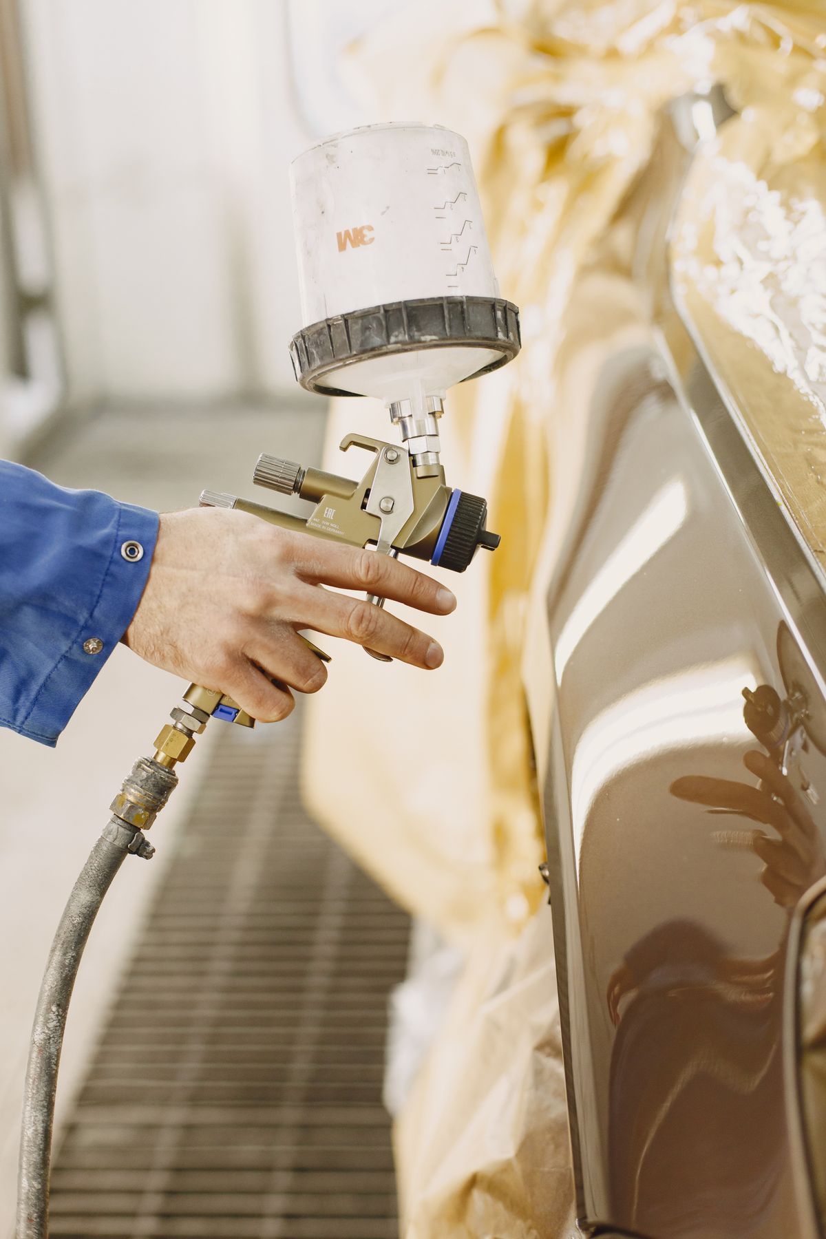 Technician applying automotive paint with a professional spray gun