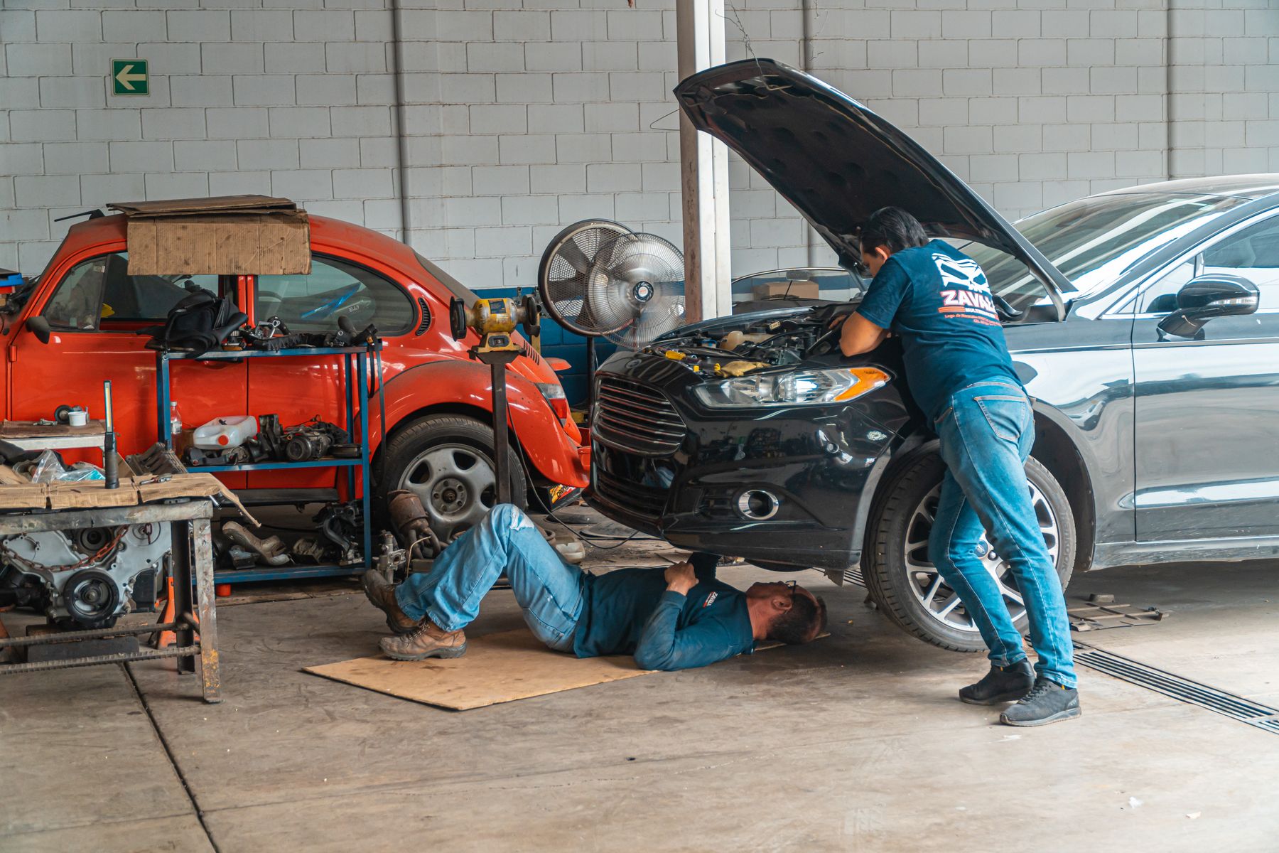 Technicians working on vehicles inside a professional repair shop